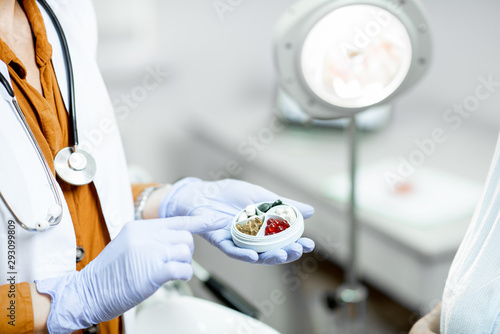 Obraz na plátně Doctor holding pillbox with some medicine in the gynecological office, close-up