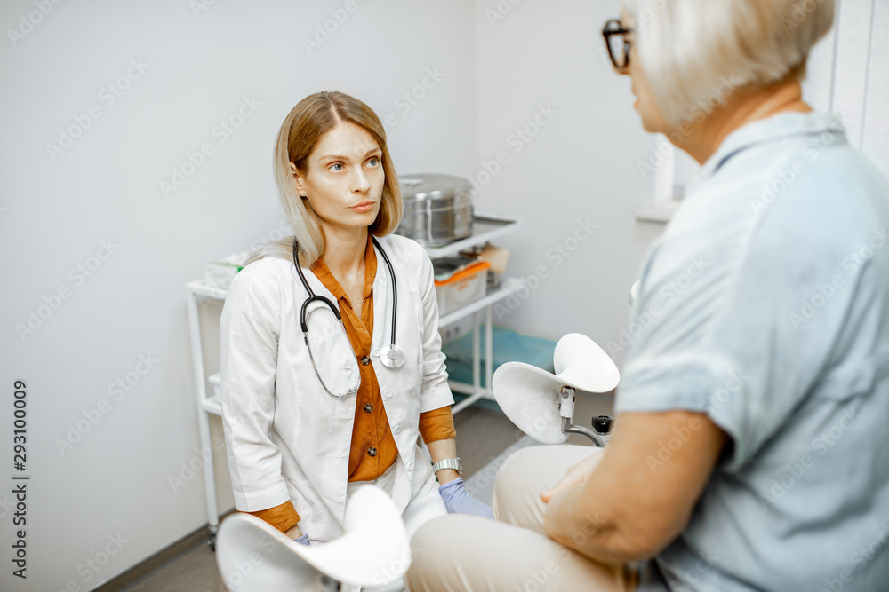Fototapeta premium Gynecologist listening to a senior woman patient during a medical consultation in gynecological office. Concept of women's health during a menopause