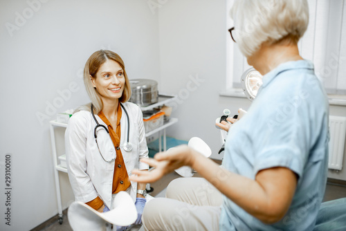 Gynecologist listening to a senior woman patient during a medical consultation in gynecological office. Concept of women's health during a menopause photo