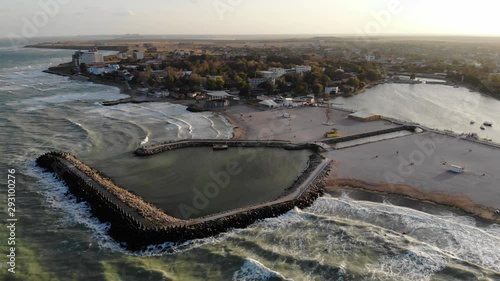 Aerial view of Costinesti beach, Romania as waves wash the shore at sunset photo