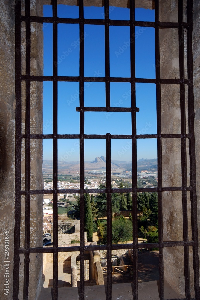 Lovers mountain seen through metal grill in castle tower (torre del homenaje), Antequera, Spain. Lovers mountain seen through metal grill in castle tower (torre del homenaje), Antequera, Spain.