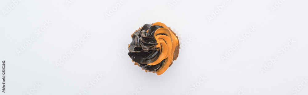 Fototapeta premium top view of delicious Halloween black and orange cupcake isolated on white, panoramic shot