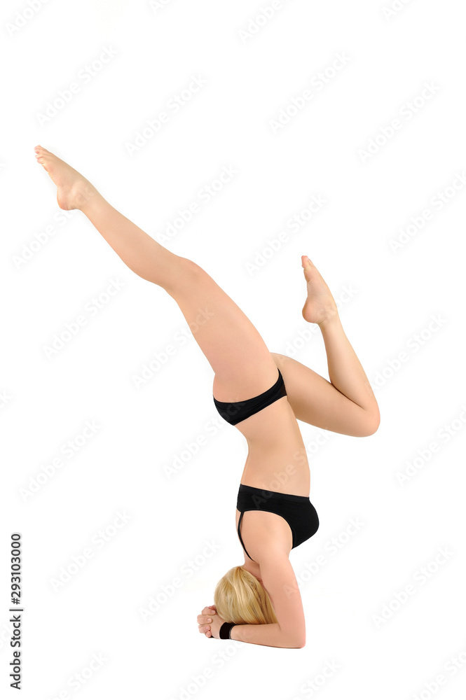 Slender girl in swimsuit is engaged in yoga in studio photo on white background stand on forearms