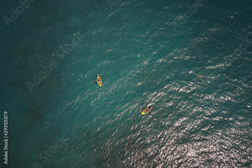 Aerial view of couple kayaking in the sea with clear turquoise water. Summer vacation
