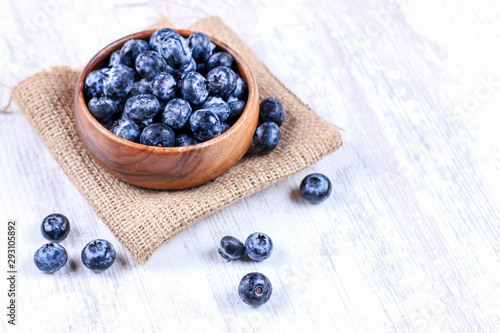Fresh blueberries in a wooden bowl on burlap