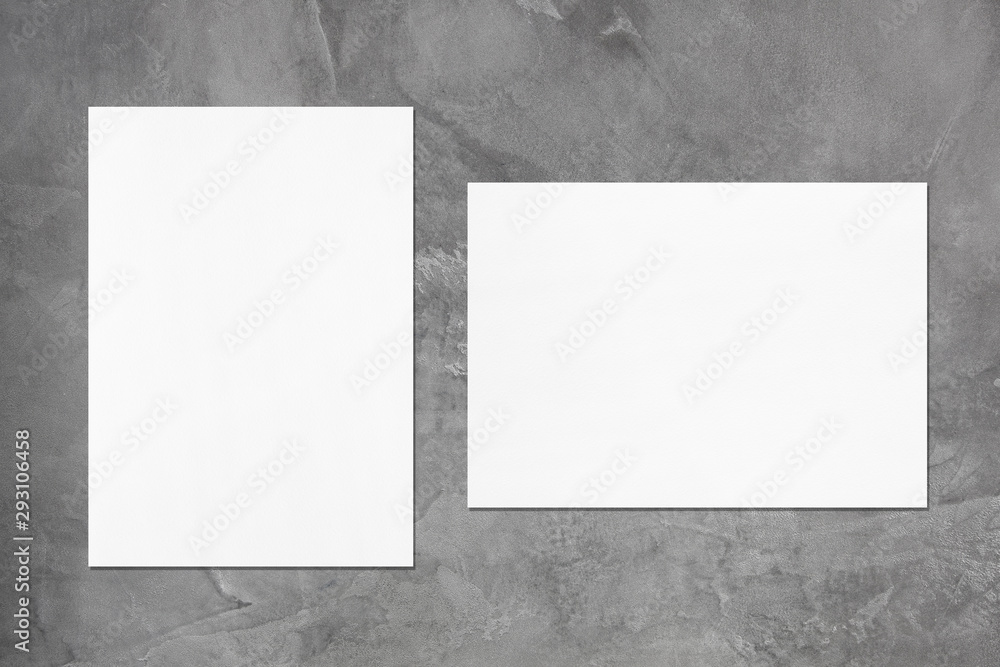 Two empty white vertical and horizontal rectangle poster or card mockups with soft shadows on dark grey concrete background. Flat lay, top view Two empty white vertical and horizontal rectangle poster or card mockups with soft shadows on dark grey concrete background. Flat lay, top view