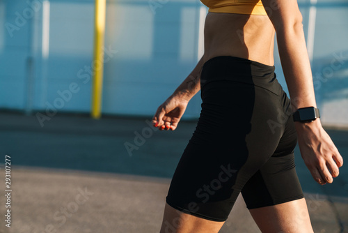 Cropped image closeup of runner woman in sportswear walking outdoors
