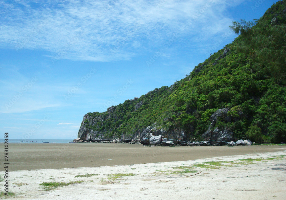 A sand beach with a cape and blue sky. A sand beach with a cape and blue sky.