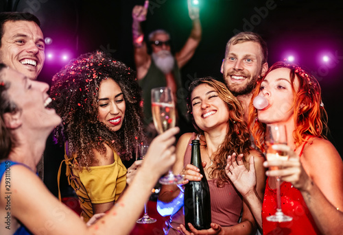 Happy friends making party drinking champagne in the nightclub - Young people having fun celebrating and dancing in the disco club - Nightlife, entertainment and youth lifestyle holidays