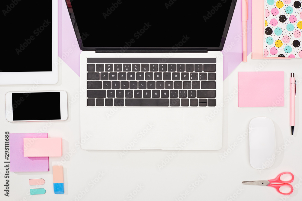 flat lay with laptop, digital tablet, smartphone with blank screen, office supplies and computer mouse on violet and white background flat lay with laptop, digital tablet, smartphone with blank screen, office supplies and computer mouse on violet and white background