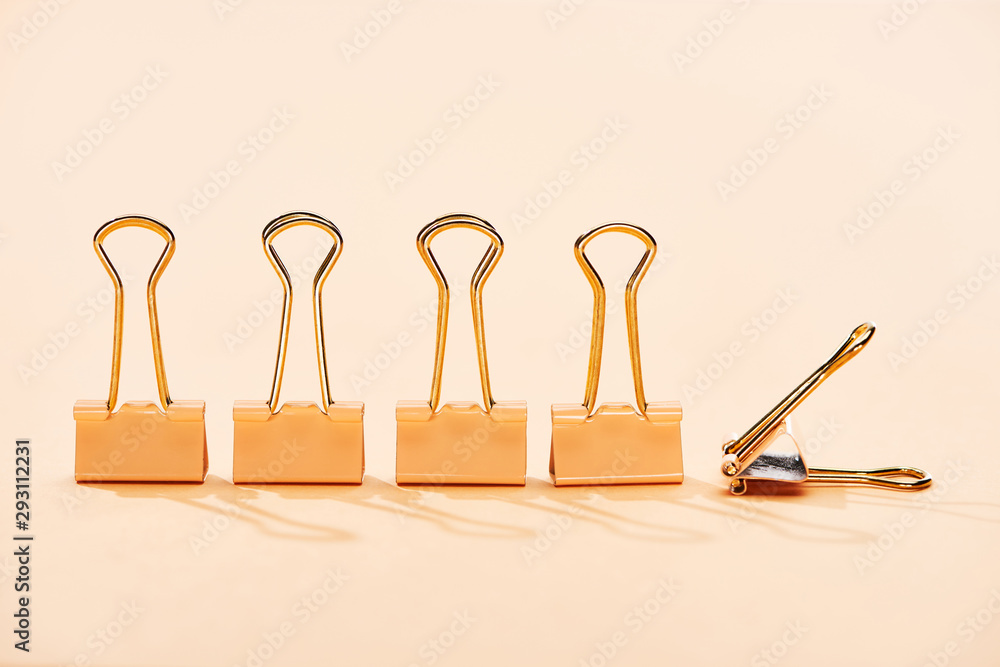 row of paper clips on beige background with copy space row of paper clips on beige background with copy space