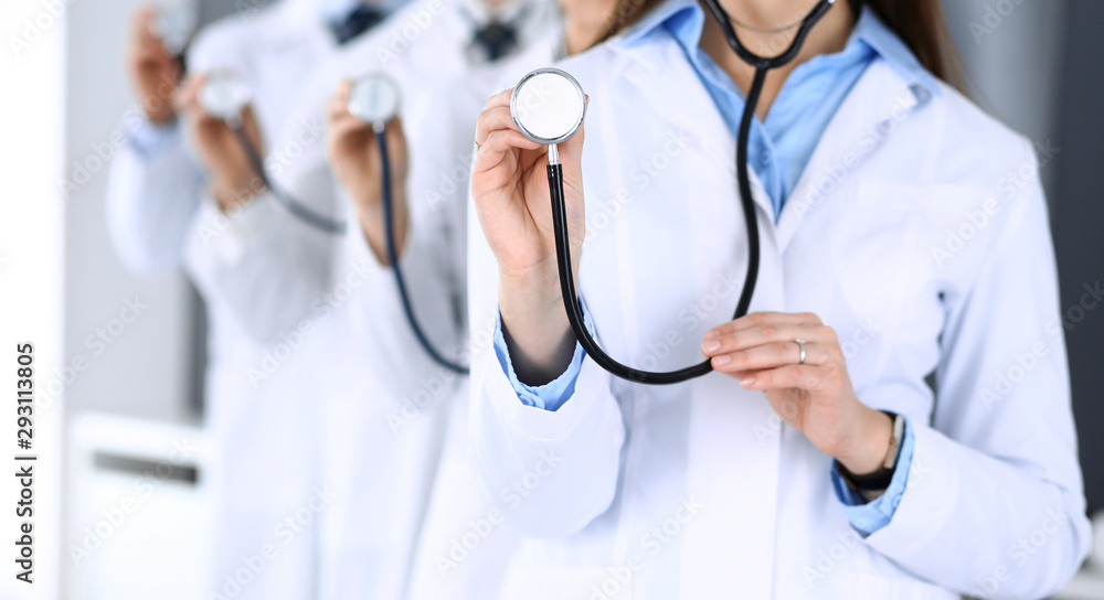 Group of doctors holding stethoscope head close-up. Physicians ready to examine and help patient. Medical help, insurance in health care, best treatment and medicine concept Group of doctors holding stethoscope head close-up. Physicians ready to examine and help patient. Medical help, insurance in health care, best treatment and medicine concept