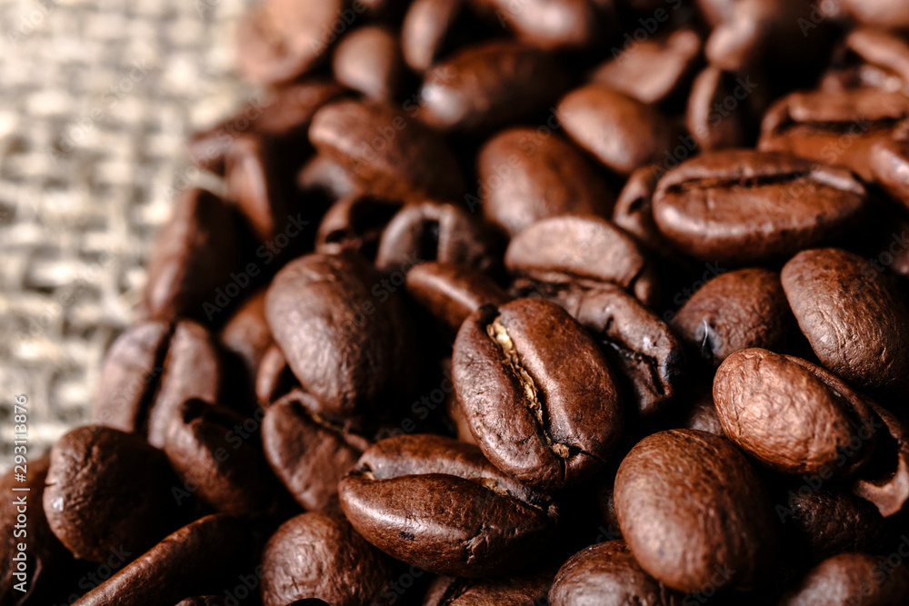 Naklejka premium Coffee beans on burlap background