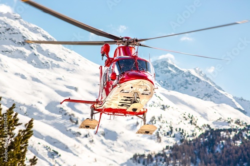 Rettungshelikopter startet mit Alpenpanorama im Hintergrund photo