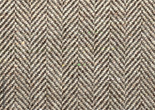 Lighte Brown woolen fabric striped zigzag. Herringbone tweed, Cashmere Background Texture. Coat close-up. Expensive men's suit fabric. High resolution