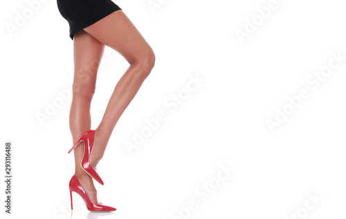 Sexy legs in short, black, mini skirt isolated on white background.