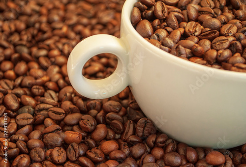 cup with coffee beans and cinnamon sticks 