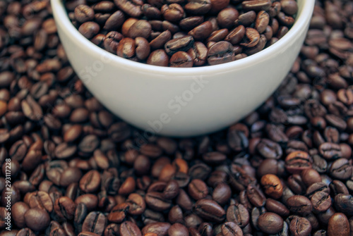 cup with coffee beans and cinnamon sticks 