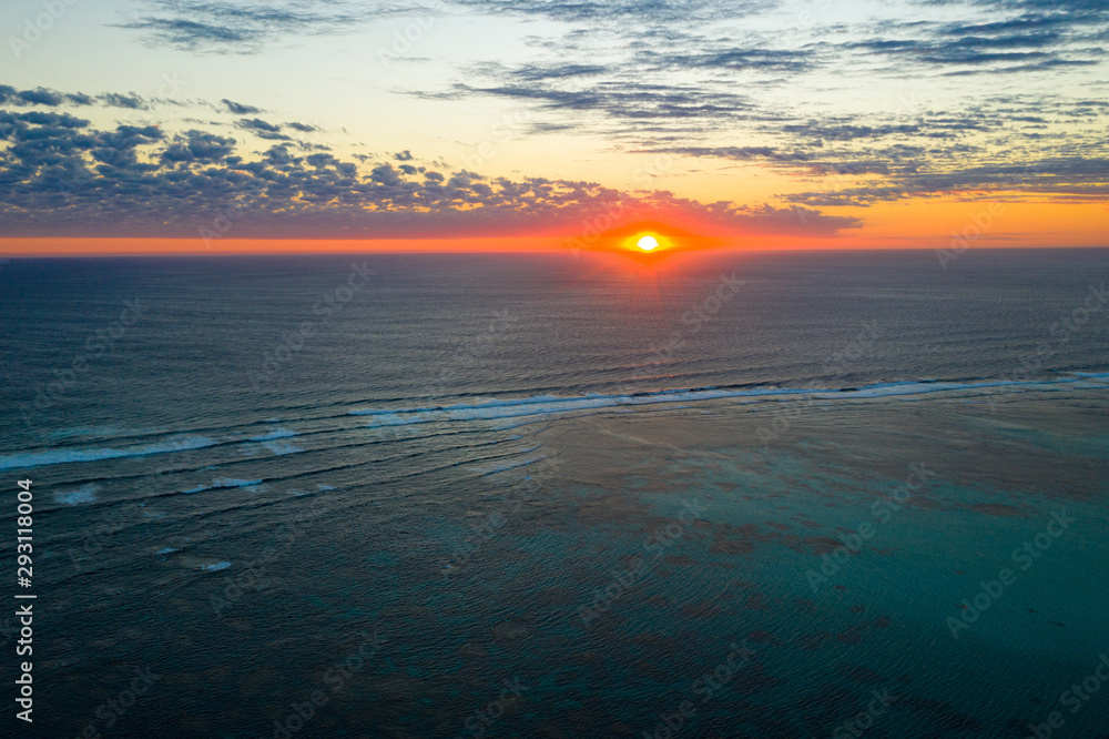 Aerial photo of sunset over sea and coral reef