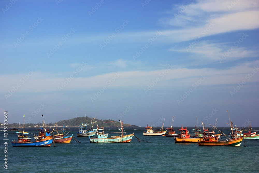 Fishing boats in the harbor await departure at sea