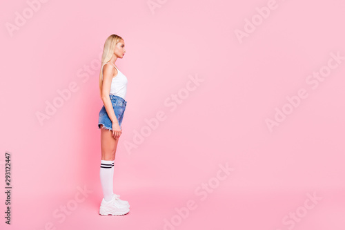 Full body profile photo of pretty lady with perfect slim shapes looking empty space wear casual trendy outfit isolated pink color background