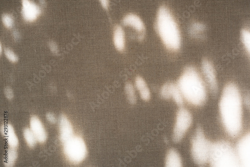 The shadow of the plant shines through the fabric. Linen fabric texture. Natural mood with shadow and light.