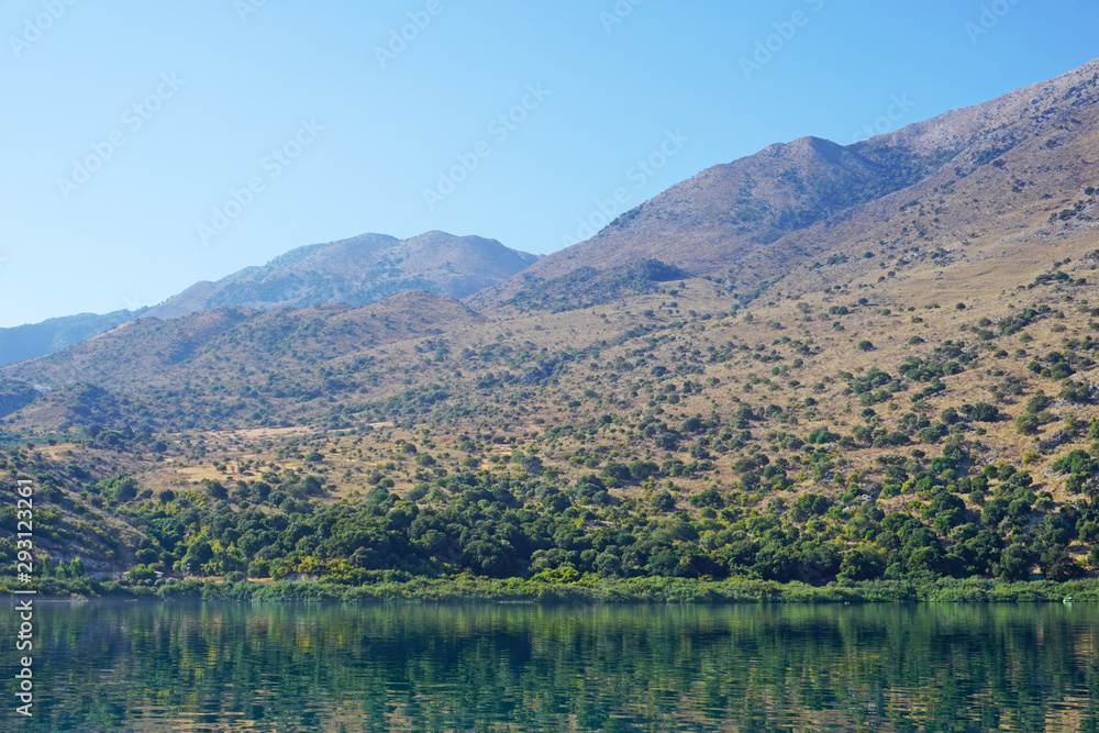 Reflection of mountains in the blue water of Lake Kournas
