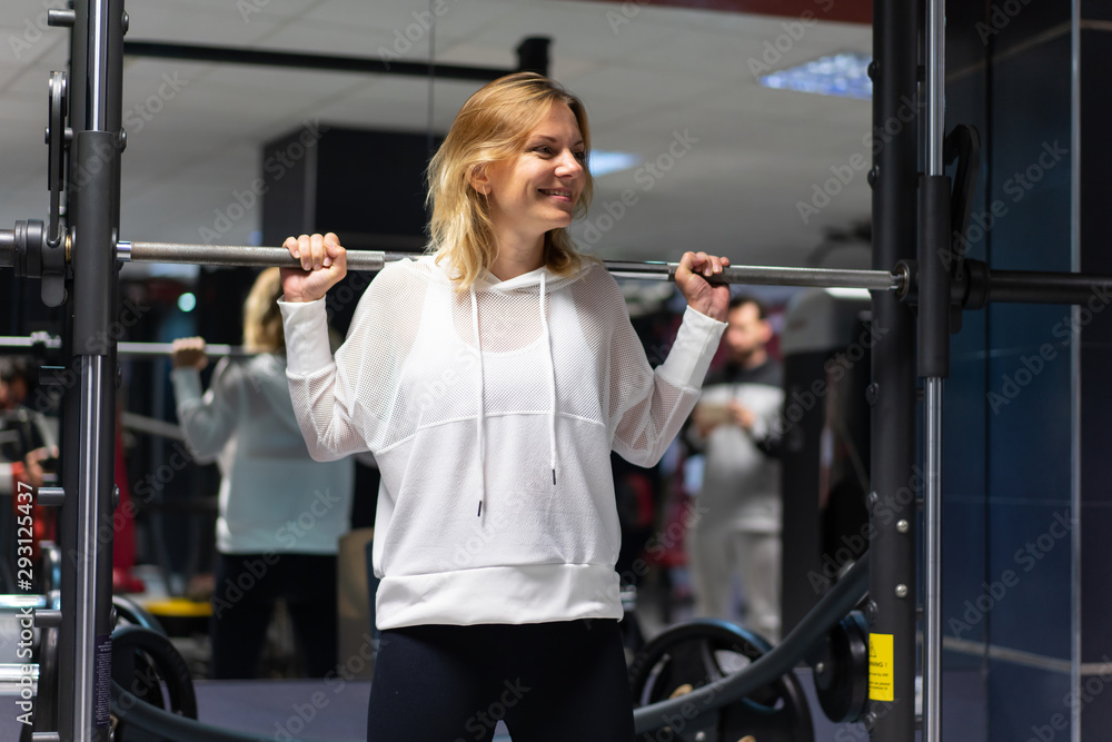 Fototapeta premium Sport Woman in a gym making weightlifting