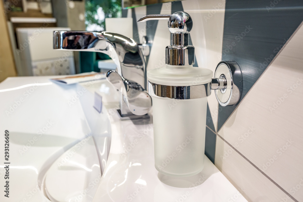 Soap and shampoo dispensers near Ceramic Water tap sink with faucet in expensive loft bathroom Soap and shampoo dispensers near Ceramic Water tap sink with faucet in expensive loft bathroom