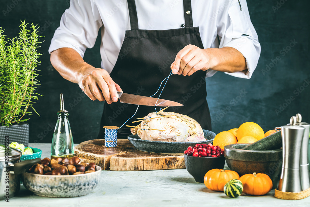 partial view of male chef in apron preparing stuffed duck partial view of male chef in apron preparing stuffed duck