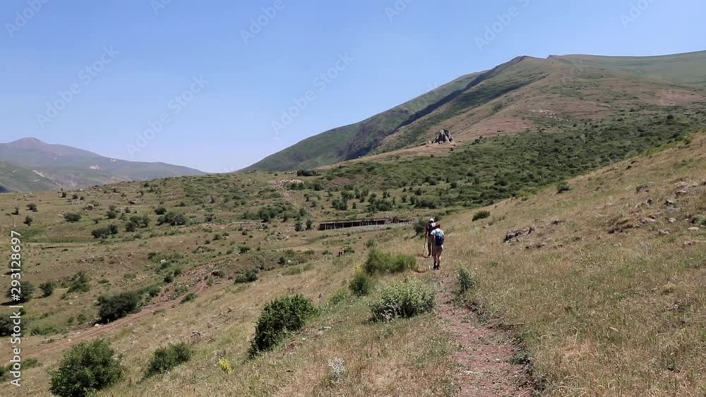 Backpackers hiking on a countryside trail trek on to their next destination.