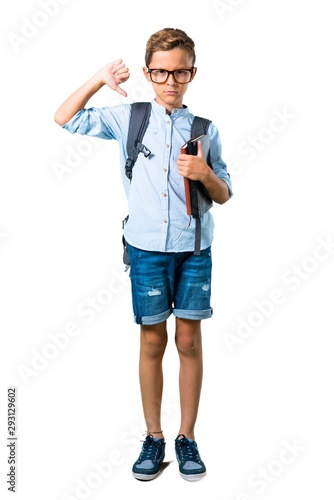Full body of Student boy with backpack and glasses showing thumb down sign with negative expression on isolated white background