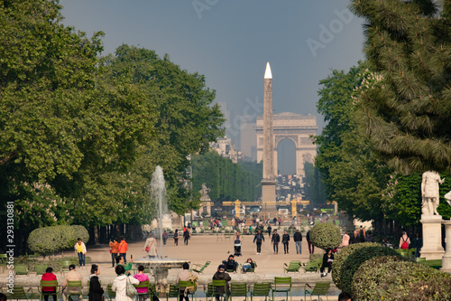 Static long shot looking through Tuileries Garden in Paris in springtime.  The Luxor Obelisk and Arc De Triomphe are in the background