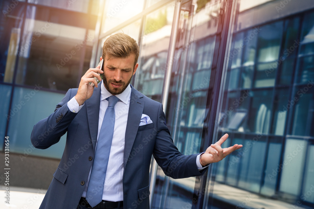 Furious businessman talking to someone over smart phone Furious businessman talking to someone over smart phone