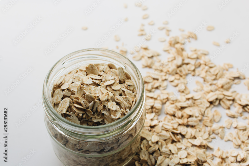 Scatterd raw oat-flakes on white background Scatterd raw oat-flakes on white background