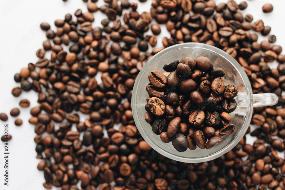 Close-up view of roasted coffee beans and glass cup Close-up view of roasted coffee beans and glass cup