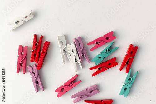 Pile of scattered clothes pegs isolated on white background