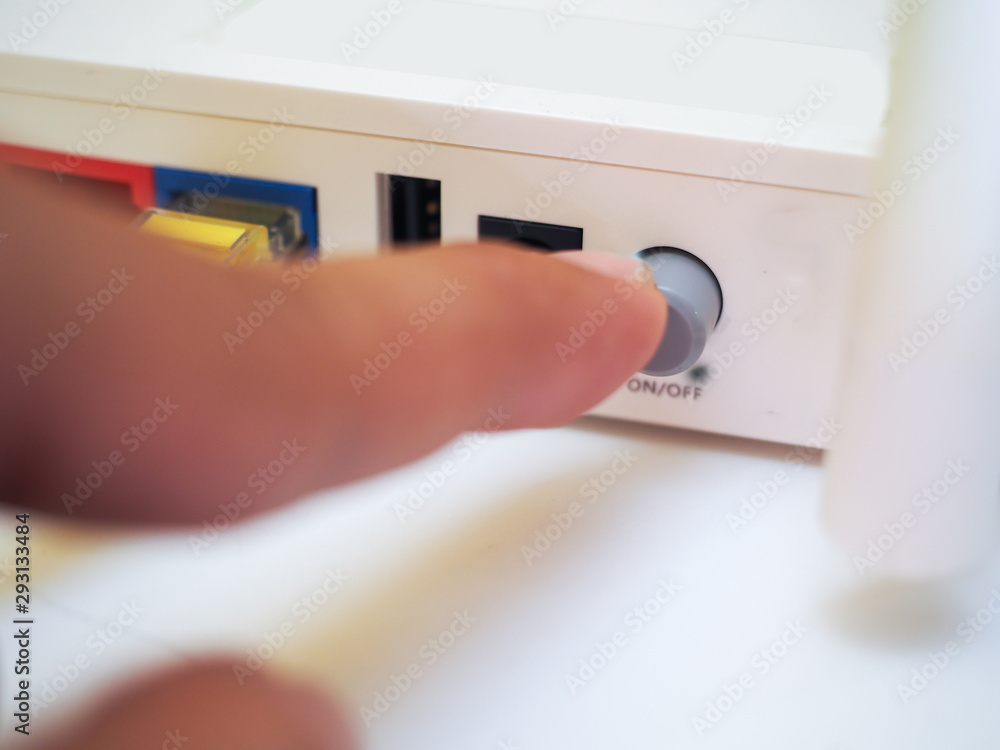 Man press with his finger on button on Wi-Fi Router.Connection n Man press with his finger on button on Wi-Fi Router.Connection n