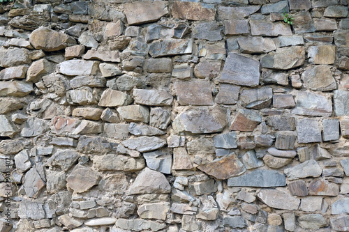 Wall from large stone texture basalt. Stone wall background. Large stones piled on top of one another.
