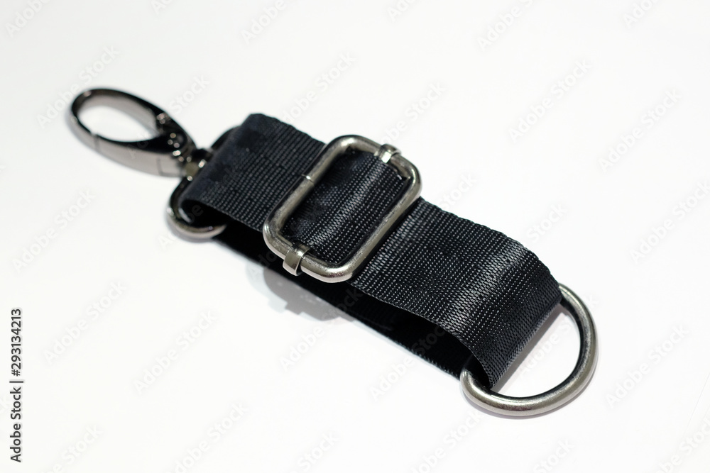 Metal banner, carabiner and half ring with a shoulder strap on a white background. Samples of handbags in dark nickel on a black belt. Metal banner, carabiner and half ring with a shoulder strap on a white background. Samples of handbags in dark nickel on a black belt.