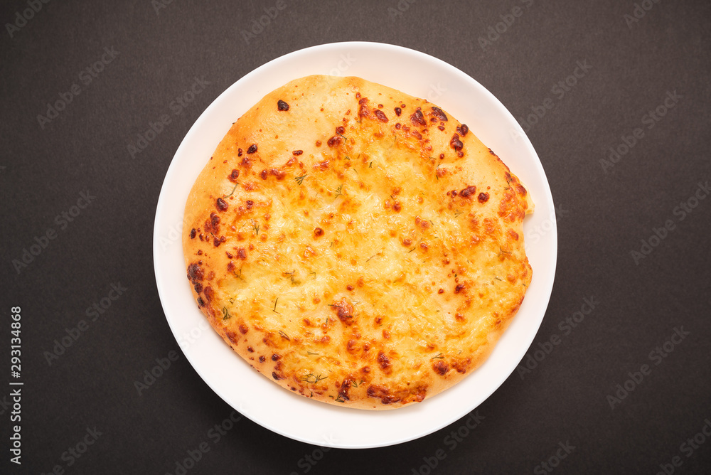 Fresh round cake on white plate on black background. Fresh round cake on white plate on black background.