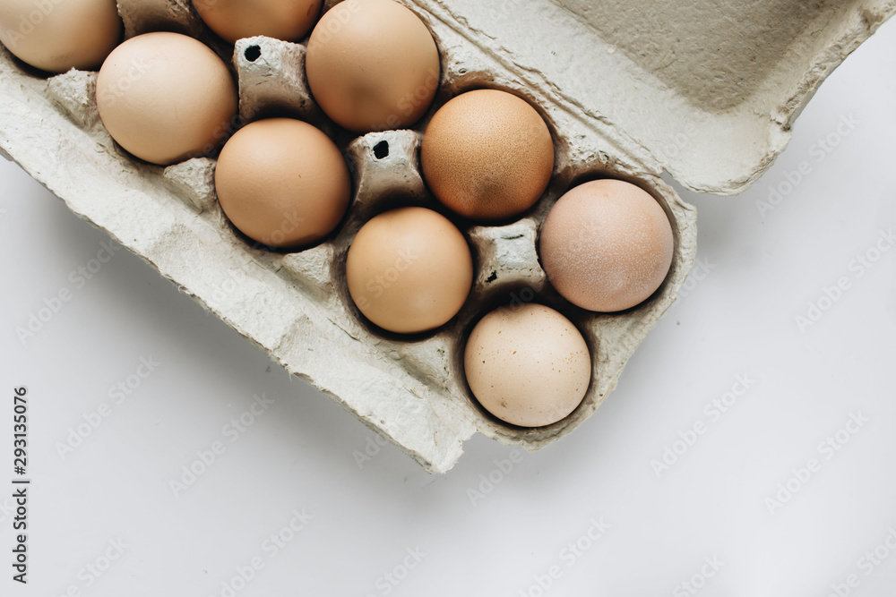 Chicken eggs in cardboard package on white background