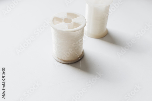 White sewing threads background closeup