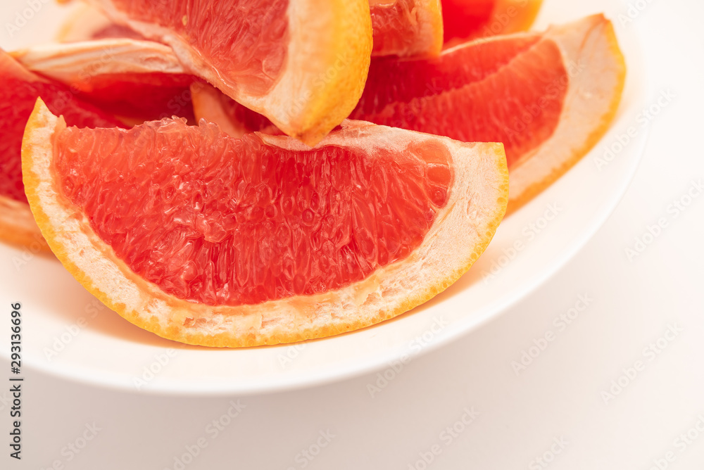 Fresh ripe juicy grapefruit on white plate on white background. Fresh ripe juicy grapefruit on white plate on white background.