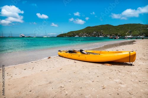 Yellow kayak on white sand beach of Bequia, St Vincent and the Grenadines.