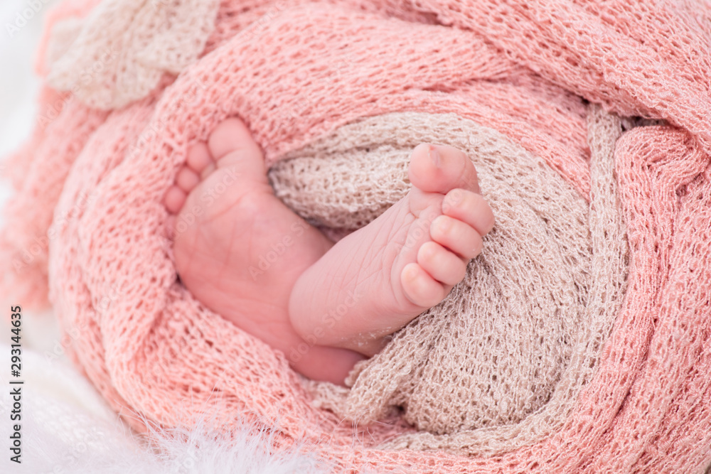 Selective focus 0-1 month newborn bare feet with tiny finger wrap by blanket or scarf Selective focus 0-1 month newborn bare feet with tiny finger wrap by blanket or scarf