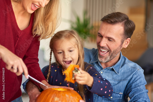 Parents helping child in carving pumpkins photo