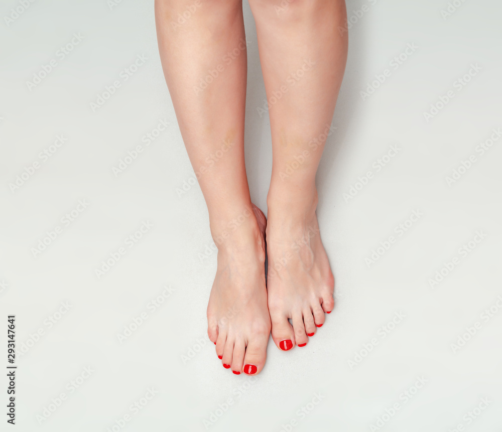 Beautiful female feet on a light gray background. Pedicure Beautiful female feet on a light gray background. Pedicure
