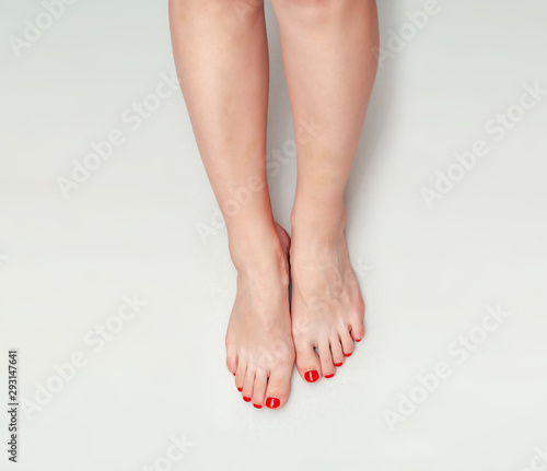 Fototapeta Naklejka Na Ścianę i Meble -  Beautiful female feet on a light gray background. Pedicure