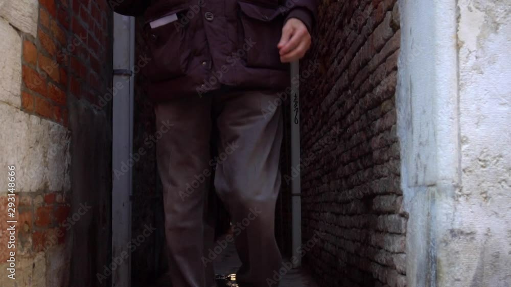 man walking along the narrow street of venice, italy man walking along the narrow street of venice, italy